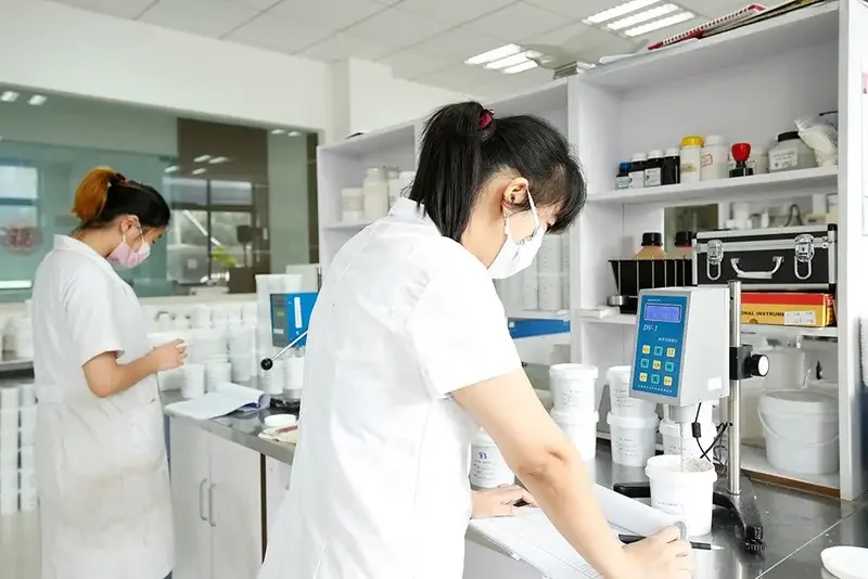 Laboratory staff using testing equipment at a partner production facility